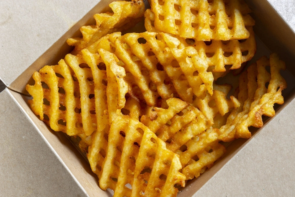 Waffle criss-cross fries takeaway in a cardboard box.