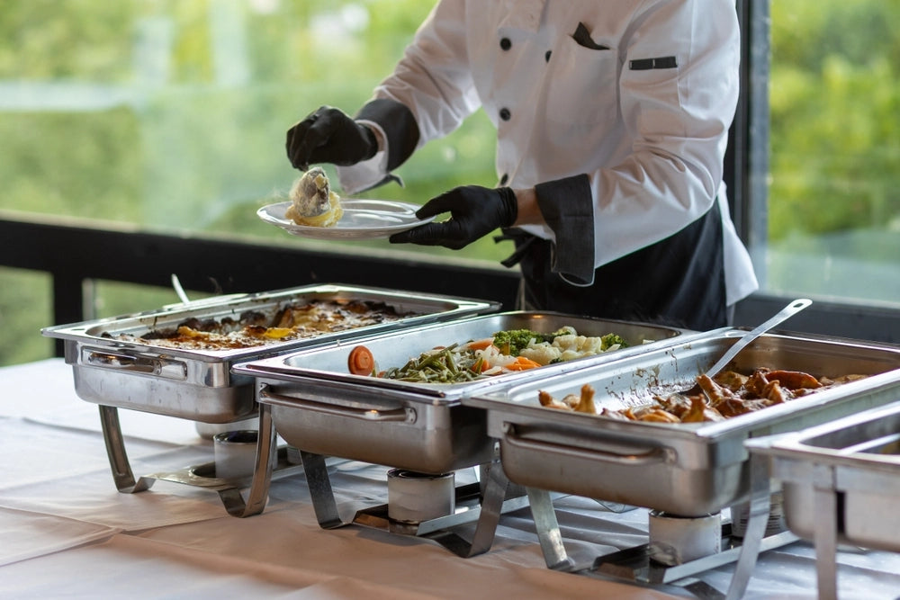 Catering staff serve food at a buffet in a modern venue during a corporate event.